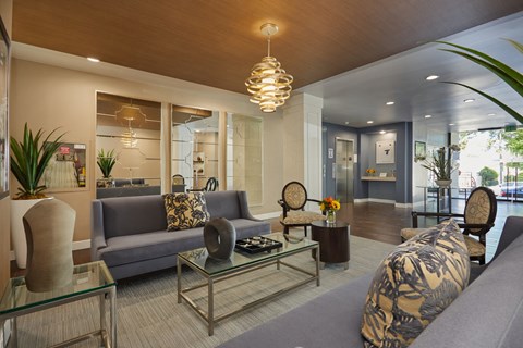 Spacious lobby with seating areas and adorned in beautiful tones of yellow, grey, and brown