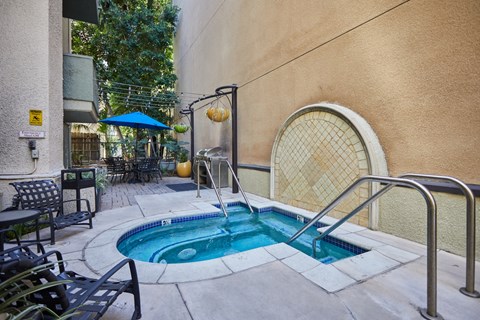Outdoor hot tub surrounded by pool chairs