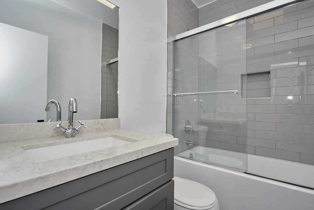 Modern bathroom with shower, toilet, sink, cabinet and sink space