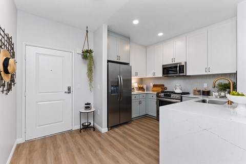 A kitchen with a white counter top and a black refrigerator.