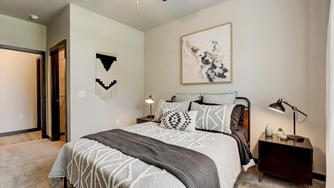 A bedroom with a large bed and a painting on the wall.