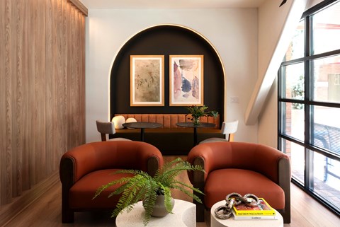 A living room with two red chairs and a coffee table.