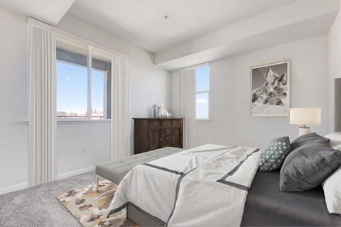 a bedroom with a bed and two windows