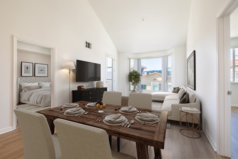 A dining room with a wooden table set for four.