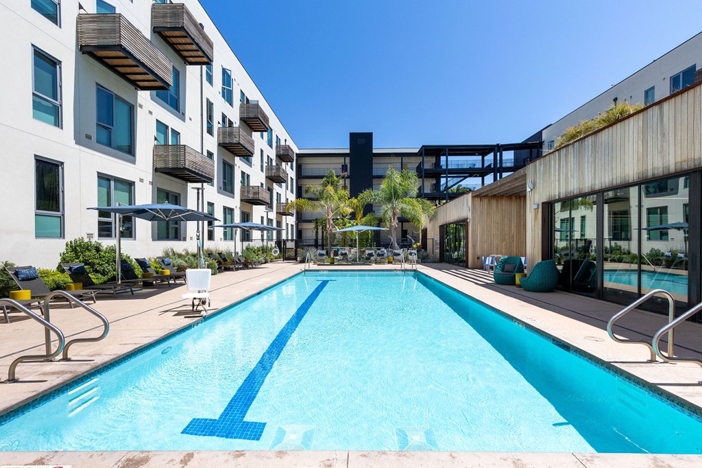 a large swimming pool in front of an apartment building