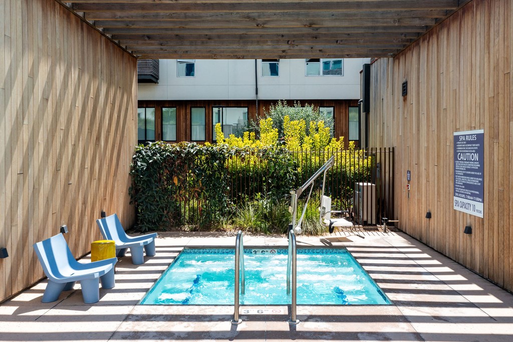 a swimming pool with two chairs and a building in the background