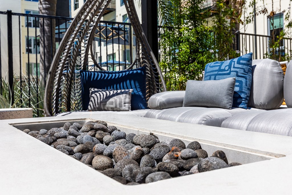 a seating area with couches and chairs and a water feature with rocks