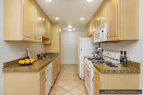 A kitchen with wooden cabinets and granite countertops.