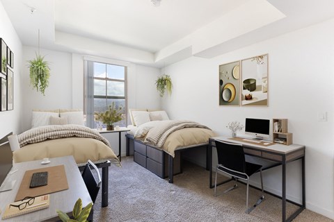 a bedroom with two beds and a desk and a window