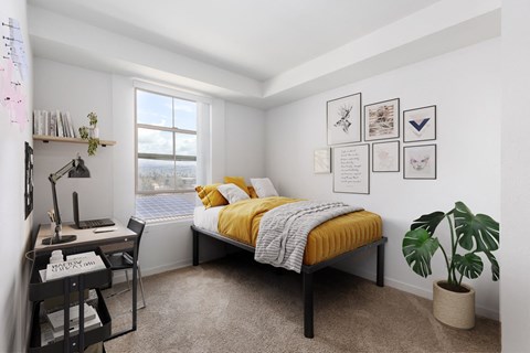 a bedroom with a bed and a desk and a window