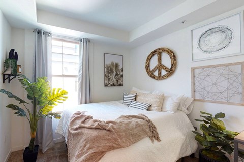 a bedroom with a bed with a blanket and pillows on it