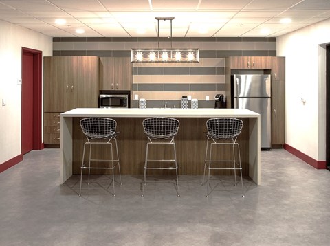 a kitchen with a counter and three bar stools