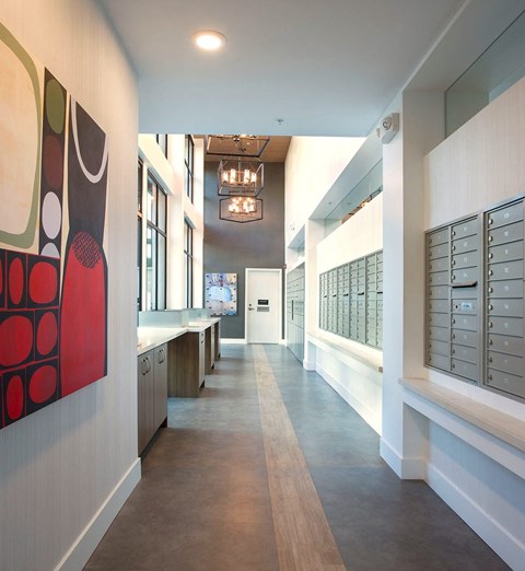 a long hallway with cabinets and a chandelier    and a painting