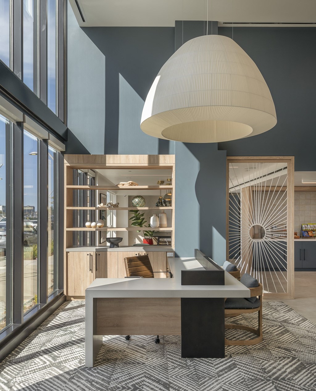 a room with a desk and a large pendant lamp