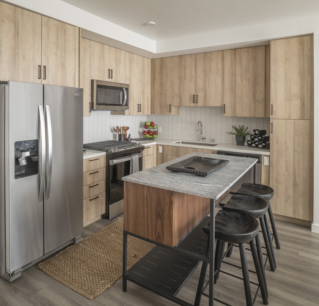 a kitchen with stainless steel appliances and a island with four stools