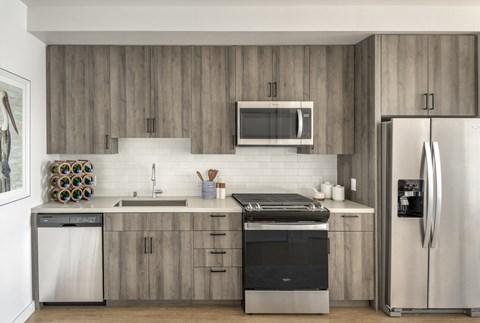 a modern kitchen with stainless steel appliances and wooden cabinets