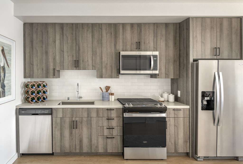a modern kitchen with stainless steel appliances and wooden cabinets