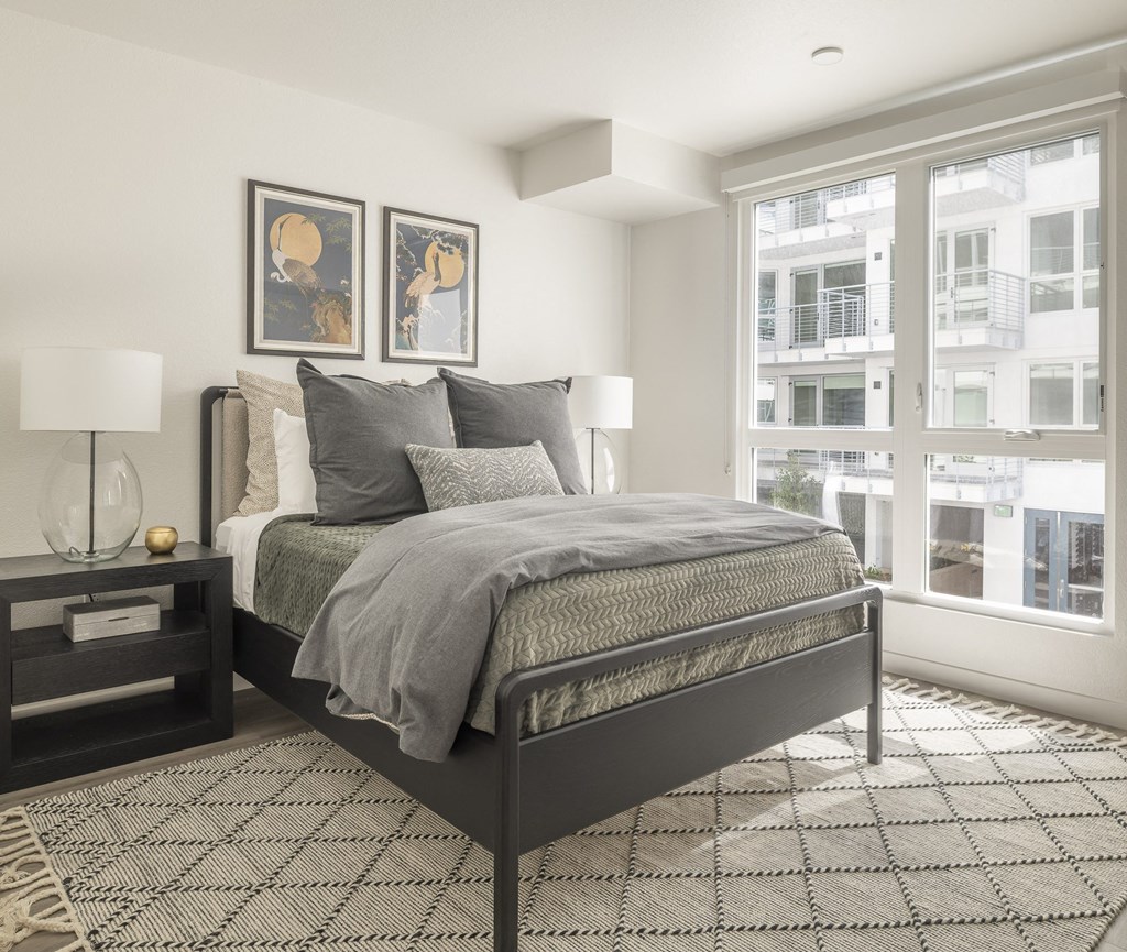 a bedroom with a bed and two windows