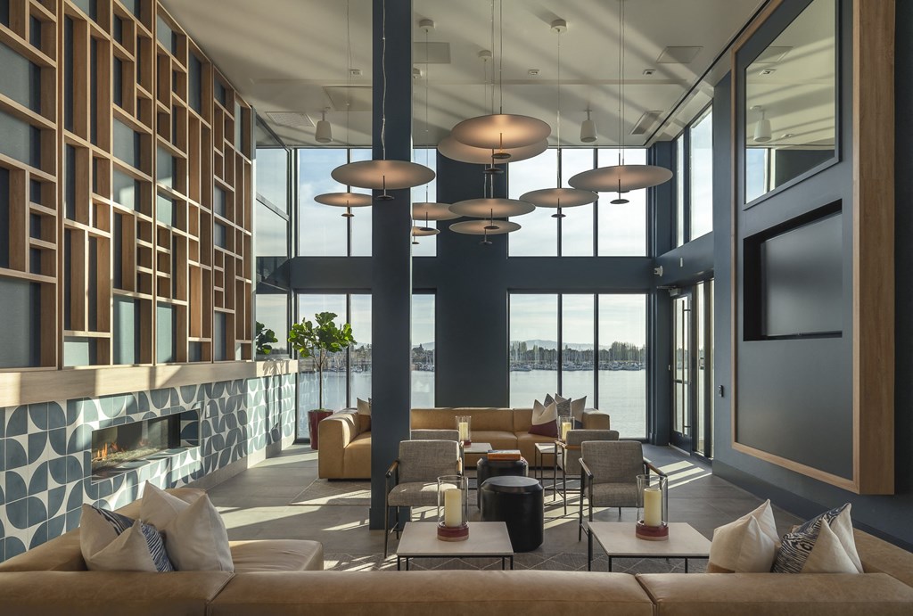 a lobby with couches and tables and large windows