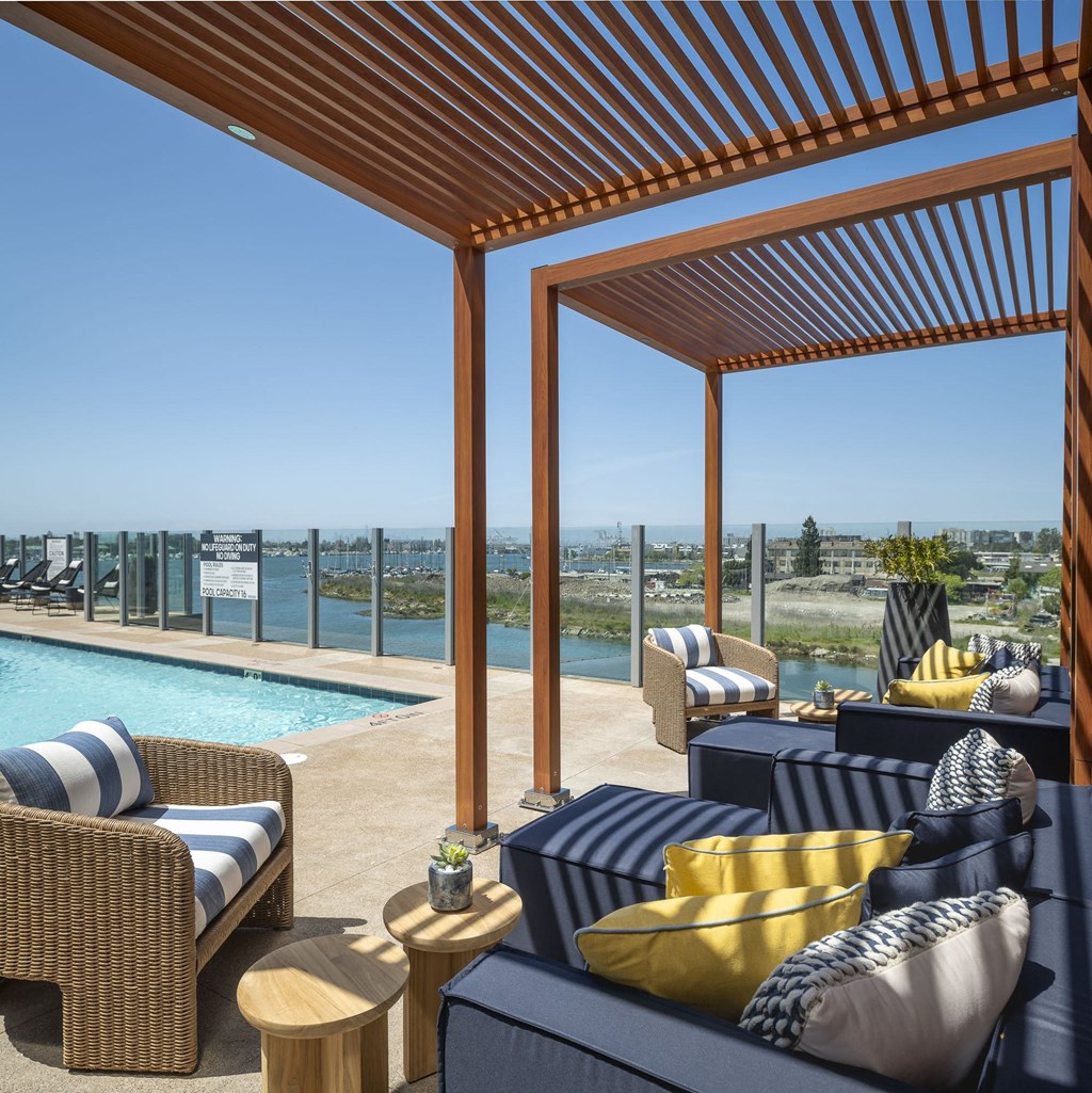 a covered patio with furniture and a swimming pool