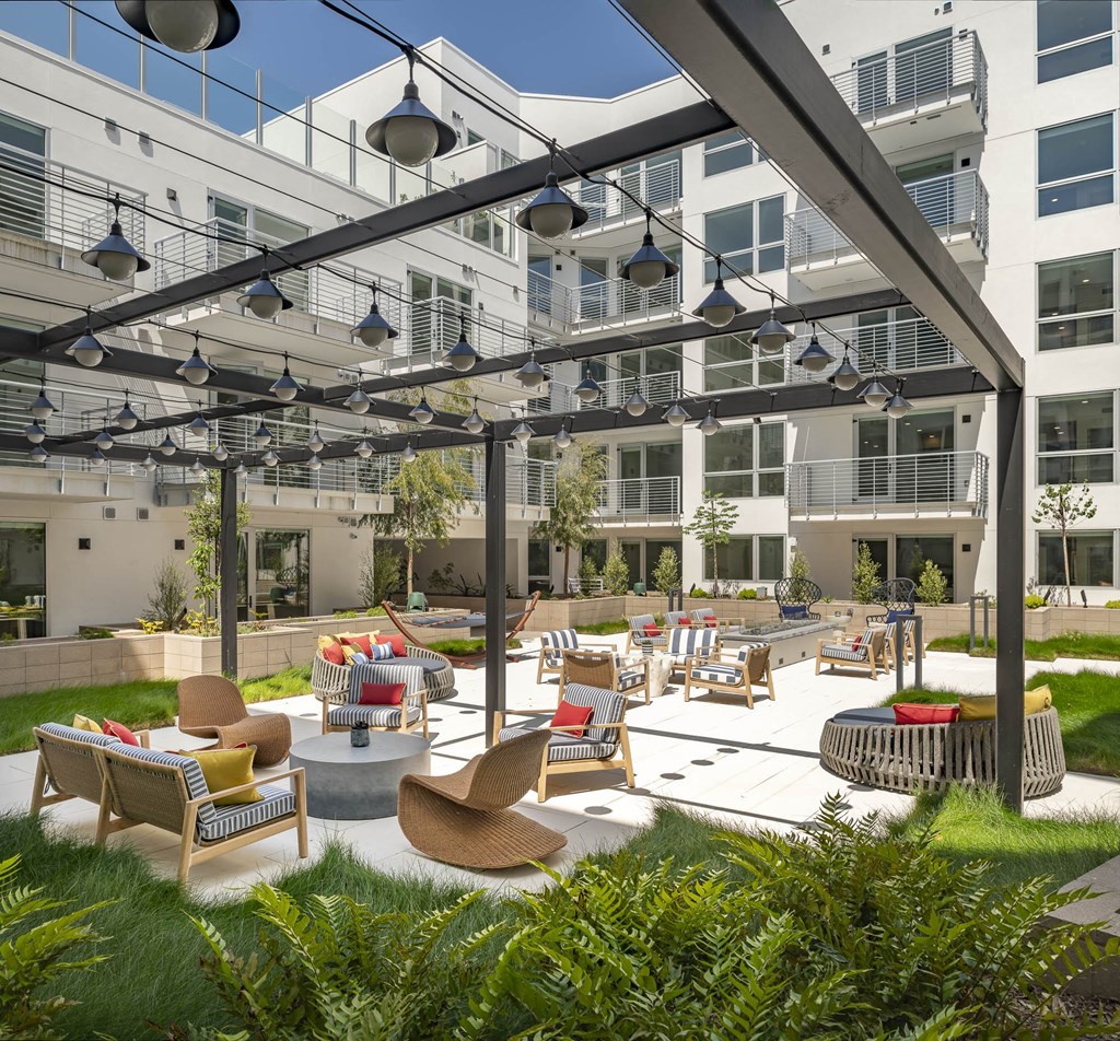 a courtyard with tables and chairs in an apartment building