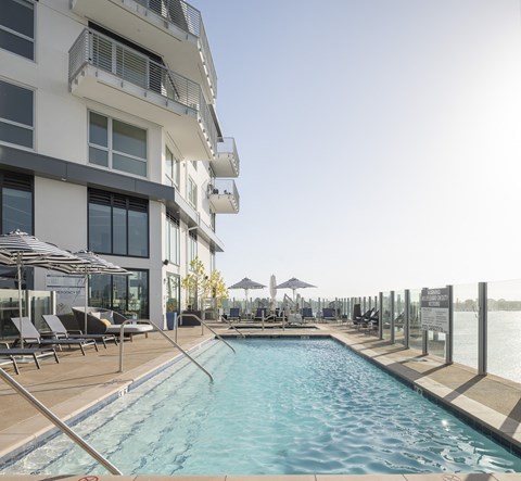 a swimming pool in front of a hotel on the water