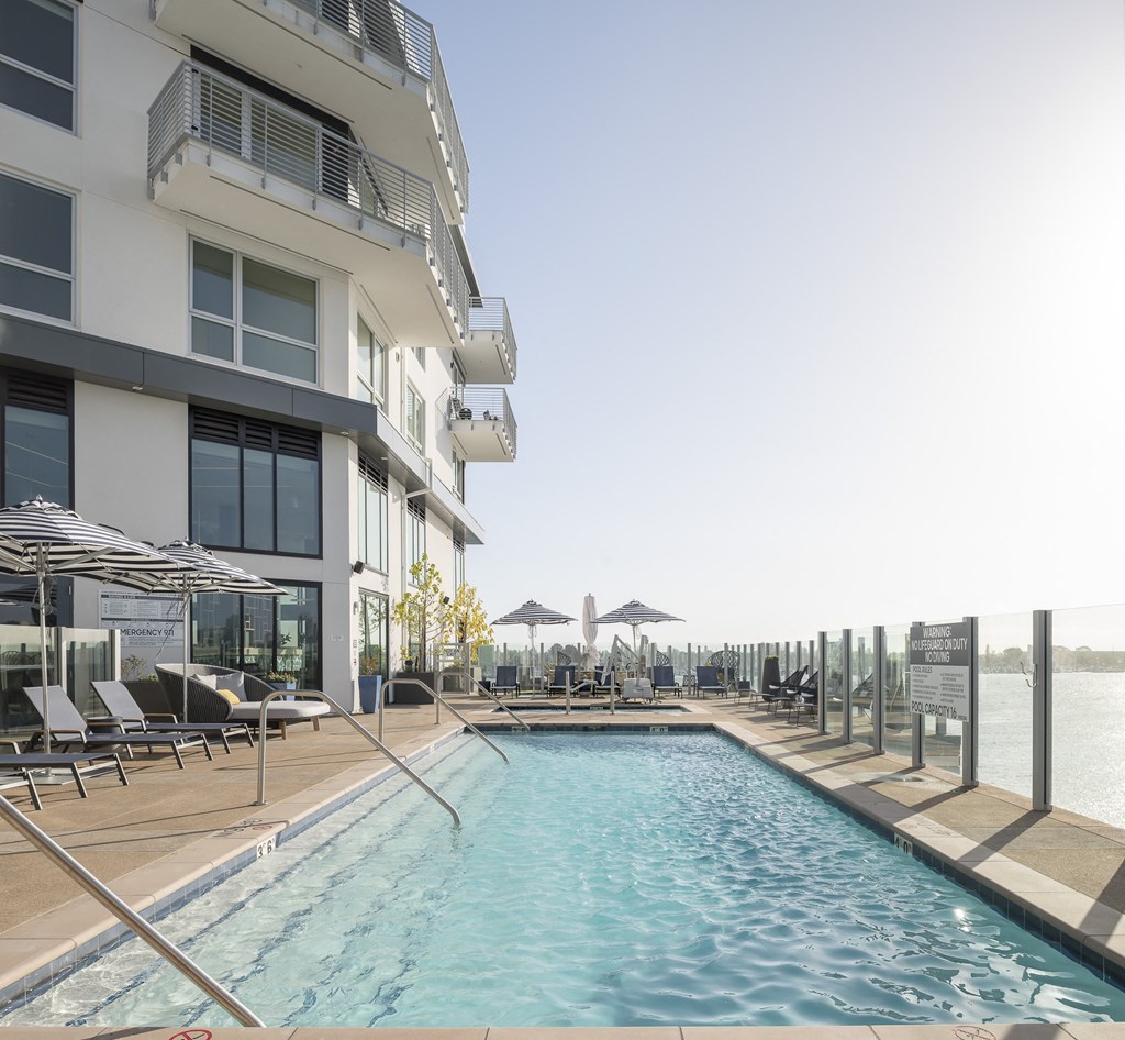 a swimming pool in front of a hotel on the water
