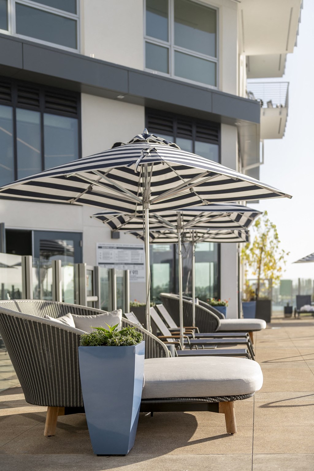 a patio with chairs and umbrellas in front of a building