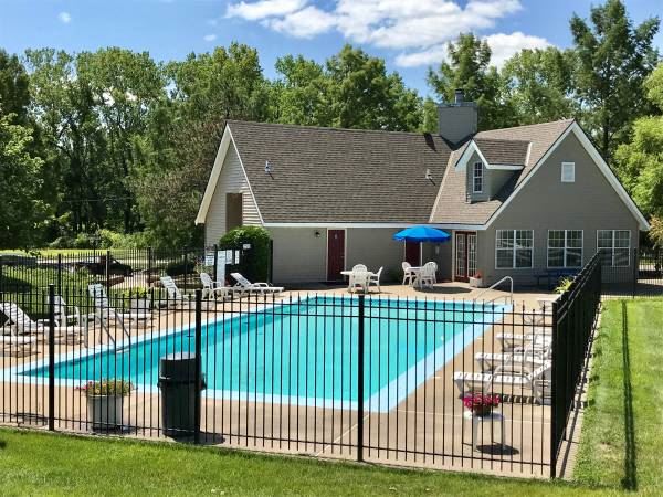 swimming pool with clubhouse in the background at sunset - Photo Gallery
