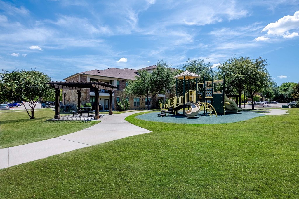 a playground in a park with a building in the background at Discovery at Craig Ranch, McKinney, Texas