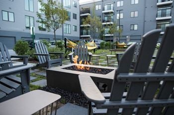 a fire pit surrounded by rocking chairs in a courtyard at Pinnex, Indianapolis, Indiana