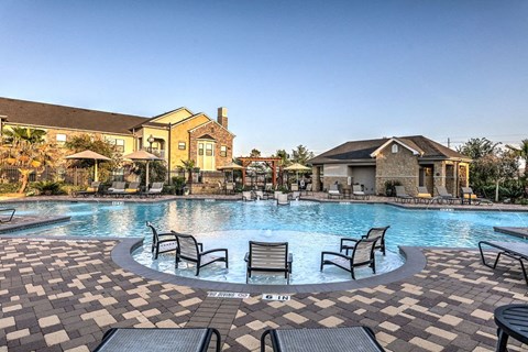 a large swimming pool with patio furniture in front of a house at Waterstone at Cinco Ranch, Katy