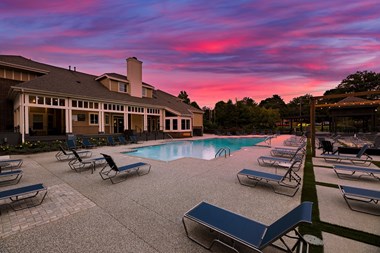 swimming pool with clubhouse in the background at sunset