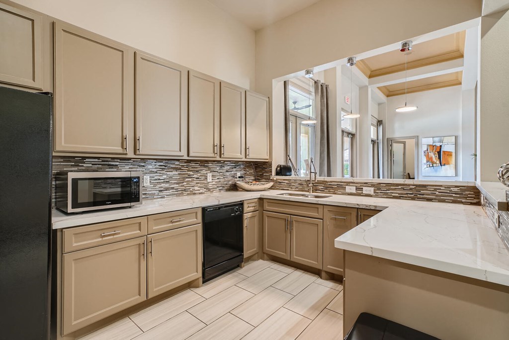 a kitchen with white cabinets and a counter top and a sink  at Grand Villas Apartments, Katy, TX, 77494