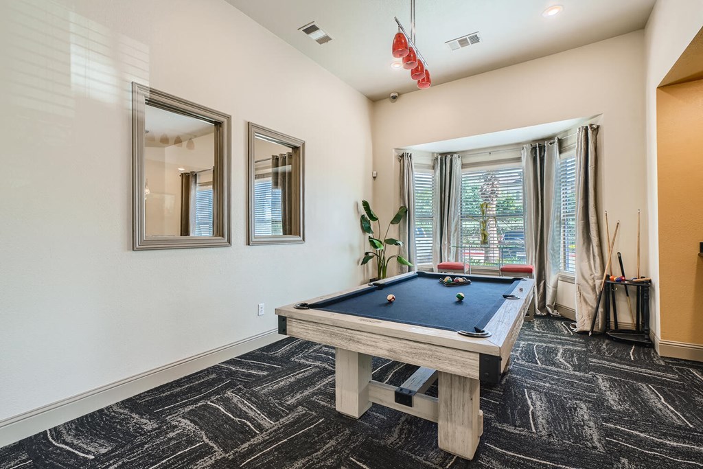 clubhouse with billiard table and large windows letting in natural light  at Grand Villas Apartments, Texas