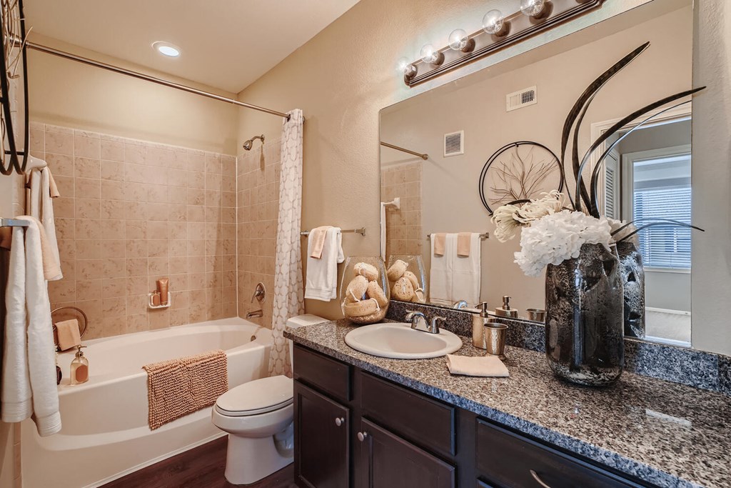 a bathroom with a sink and a toilet and a tub  at Grand Villas Apartments, Texas