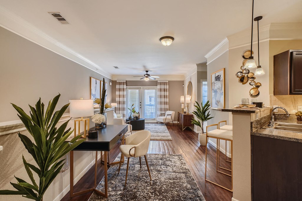 a living room with a kitchen and a dining room  at Grand Villas Apartments, Texas