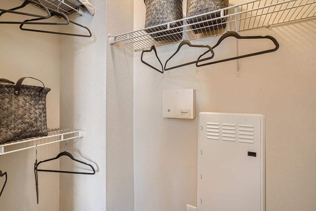 a laundry room with a clothes rack and a dryer  at Grand Villas Apartments, Texas, 77494