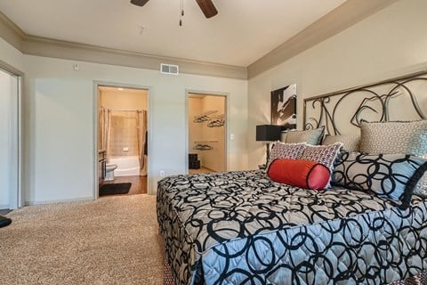 a bedroom with a bed and a closet  at Grand Villas Apartments, Katy, Texas