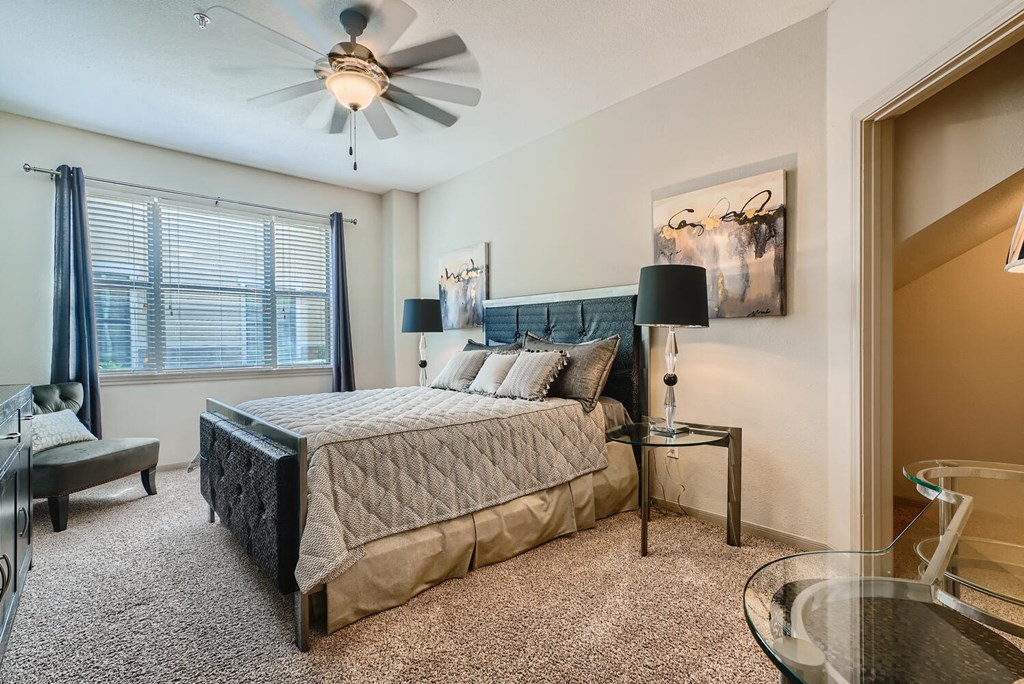 bedroom area with bed, walk-in closet and other furniture at Grand Villas Apartments, Texas