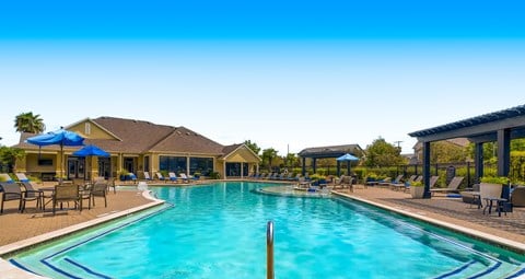 a swimming pool with chairs and umbrellas at the club house at Grand Villas Apartments, Katy