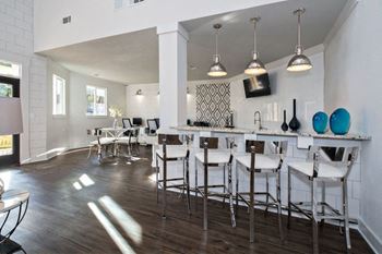 a living room with a bar and a kitchen with stools  at Butternut Ridge, North Olmsted, 44070