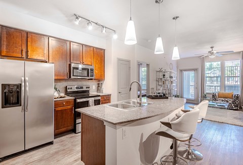 a kitchen with a island and a stainless steel refrigerator