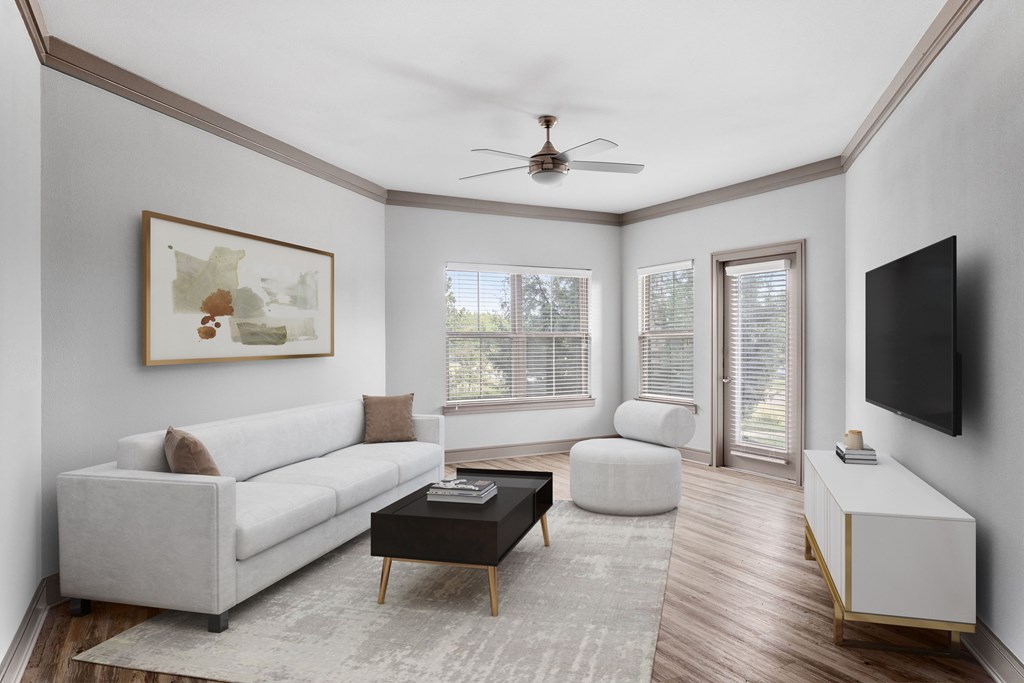 A living room with a white couch, a coffee table, and a painting on the wall.