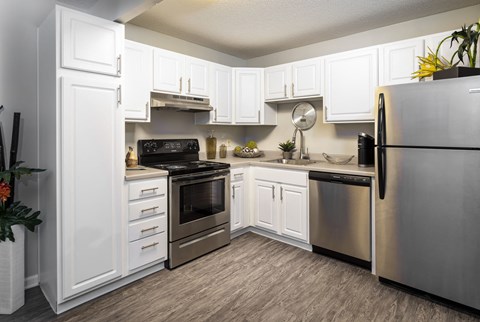 a kitchen with stainless steel appliances and white cabinets