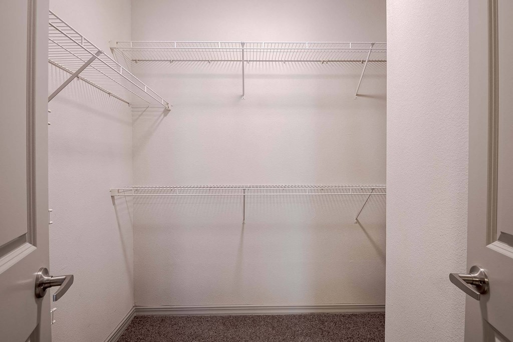 a walk in closet with empty shelves in a white room at Discovery at Craig Ranch, McKinney, Texas