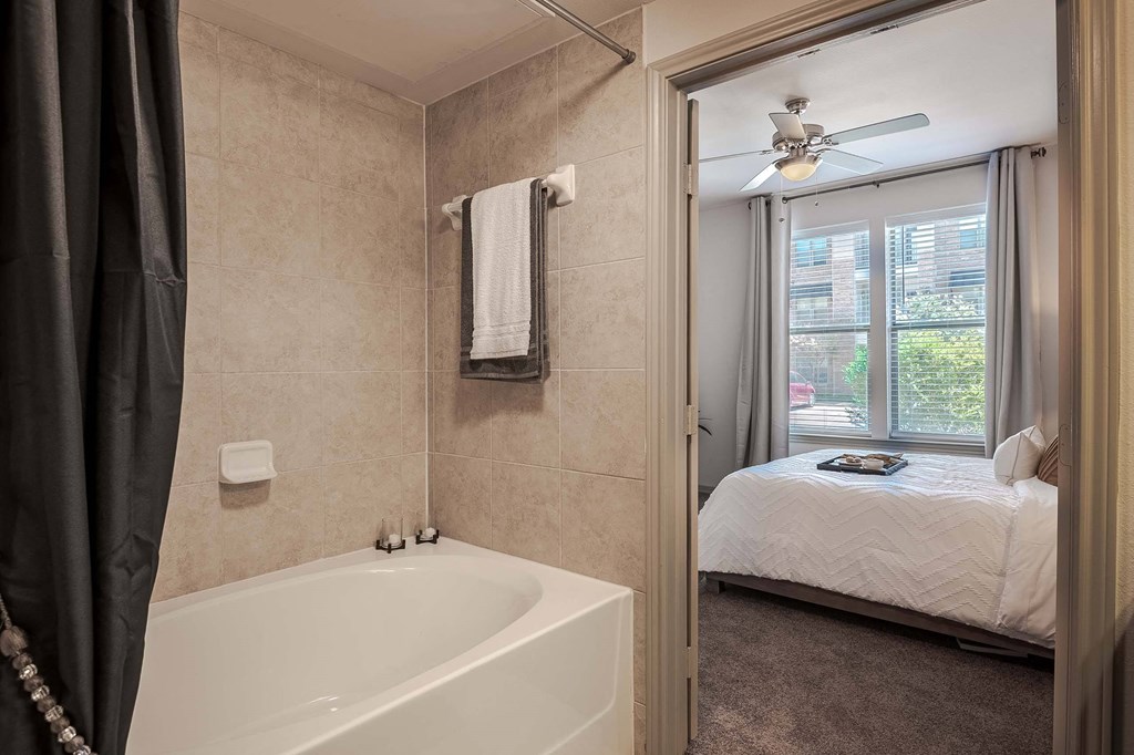 a bathroom with a tub and a bedroom with a bed at Discovery at Craig Ranch, Texas