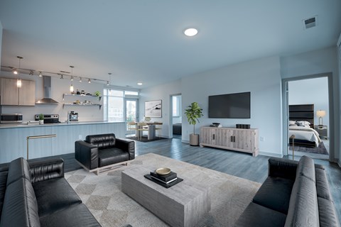 A modern living room with a black leather couch and a grey coffee table.
