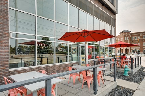 Table with chairs and Umbrella outside the building at 747 Apartments, Indiana, 46202