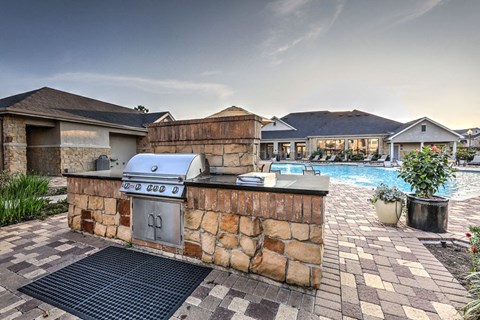 a barbecue grill in a backyard next to a swimming pool at Waterstone at Cinco Ranch, Katy, Texas